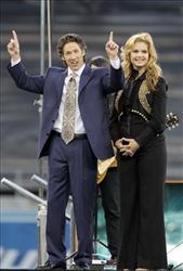 Lakewood Church pastor Joel Osteen, with his wife Victoria, talks at Dodger Stadium during his "A Night of Hope" event on Saturday April 24, 2010. (AP Photo/Richard Vogel)