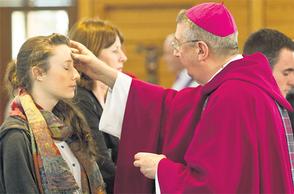 Archbishop Diarmuid Martin marks a student?s forehead with the blessed ash at Mass at UCD yesterday. Photo: Mark Condren