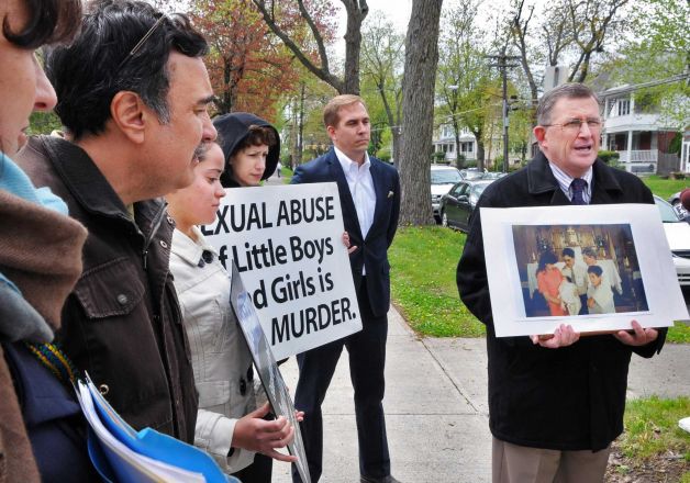 Road to Recovery president Robert Hoatson, at right, holds photos of alleged sexual abuse victims Martin Morales and his brother Ivan Morales Jr. during a news conference outside the Albany Diocesan headquarters in Albany Tuesday April 24, 2012. (John Carl D'Annibale / Times Union)