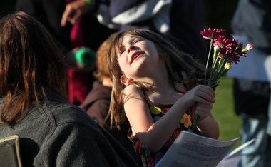 Ava McCarthy dances with a small bouquet of flowers before the May Crowning ceremony outside of St. Patrick Catholic Church in Cleveland.
