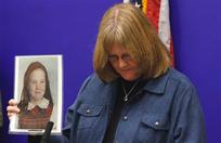 FILE - In this Thursday, Jan. 27, 2011 file photo, Becky Ianni holds a photo of herself as a child during a news conference on legislation dealing with the statue of limitations on how long victims of sex abuse have to file civil lawsuits at the Capitol in Richmond, Va. While many Americans are riveted by the Penn State sex abuse trial, it has been particularly wrenching - and sometimes heartening - for those who were themselves victims of abuse in their youth. Ianni waited until she was 48 to speak out about abuse she says she endured at the hands of a priest when she was 9 and 10. When she decided to speak out, in 2006, she went before a church review board to make her allegations, and burst into tears as she underwent questioning. She said memories of that encounter resurfaced as she followed the reports of some of the Sandusky witnesses fighting back tears during their testimony. She admitted to a trace of envy that the witnesses have a chance to confront Sandusky. "My perpetrator committed suicide in 1992," she said. "I had no chance to confront him."(AP Photo/Steve Helber)