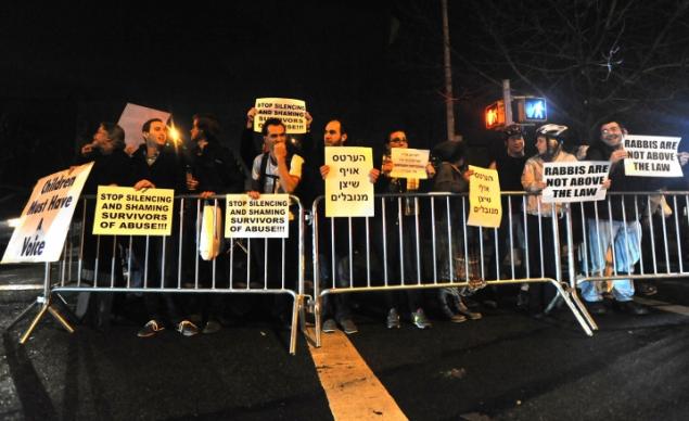Protestors held signs and voiced their opposition to suppport of Nechemya Weberman, on trial in for alleged sexualy abusing a Hasidic girl years ago.