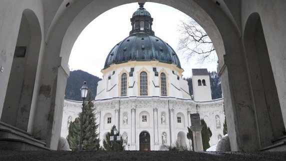 Durch den Eingang zum Kloster Ettal im Landkreis Garmisch-Partenkirchen ist die Kloster- und Pfarrkirche zu sehen. Im Gegensatz zu den deutschen Bischofen will die Benediktinerabtei Ettal ihre Studie zur Aufarbeitung des Missbrauchsskandals hinter Klostermauern schon bald vorstellen.