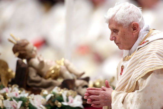Pope Benedict XVI walks in front a manger as he attends the Christmas night mass at the St. Peter's Basilica on Dec. 24, 2012 in Vatican City, Vatican.