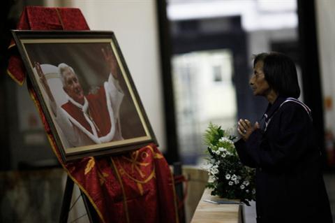 A woman prays in front of a photograph of Pope Benedict XVI inside Sao Paulo Cathedral February 22, 2013. REUTERS/Nacho Doce