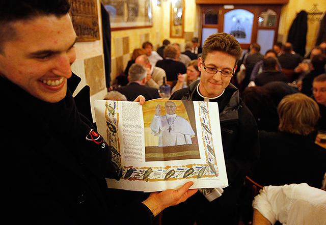 Seminarians from Australia show a special edition of the Vatican newspaper Osservatore Romano to diners from Ireland at a restaurant in Rome on Thursday, March 14. Jorge Mario Bergoglio of Argentina was elected as the new leader of the troubled Roman Catholic Church on Wednesday, taking the name Francis and becoming the first non-European pontiff in nearly 1,300 years. Reuters/Chris Helgren