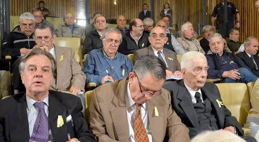 Menendez y otros acusados en la causa de La Perla con escarapelas amarillas y blancas.