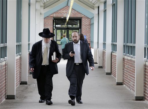 Yosef Kolko, 39, right, walks with an unidentified man, near the Ocean County Courthouse in Toms River, N.J., Thursday, May 9, 2013, during a break in his trial on sexual assault charges. Testimony continues in the trial of the yeshiva teacher accused of sexually abusing a boy at a summer camp where he was a counselor. Prosecutors say the boy's parents were pressured by members of their Orthodox Jewish community to drop the charges and let a rabbinical court deal with them.