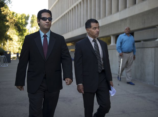 The Rev. Uriel Ojeda, left, leaves the Sacramento County Courthouse on Friday with his attorney, Jesse Ortiz. The priest's trial on molestation charges was set for Dec. 6.