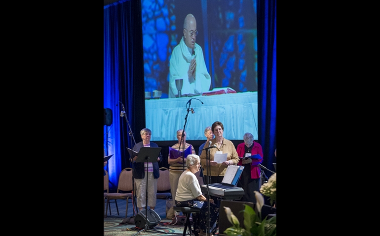Projected on a screen above choir Archbishop Carlo Maria Vigano, apostolic nuncio to the United States, celebrates Mass Aug. 14 during the Leadership Conference of Women Religious assembly. (CNS photo/Roberto Gonzalez)