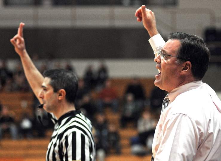 Bill Gibbons signals a play for his team, while referee Michael Motta signals a three-point shot, in a game on Nov. 28, 2012. (T&G Staff File Photo/STEVE LANAVA)