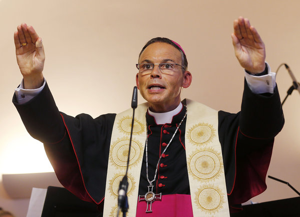 German Bishop Franz-Peter Tebartz-van Elst of Limburg, shown in this August photo blessing a new kindergarten in Frankfurt, was suspended by Pope Francis on Wednesday as the Vatican investigates a scandal over his lavish spending on trips, cars and a $42-million palatial residence renovation. (Michael Probst / Associated Press / August 29, 2013)