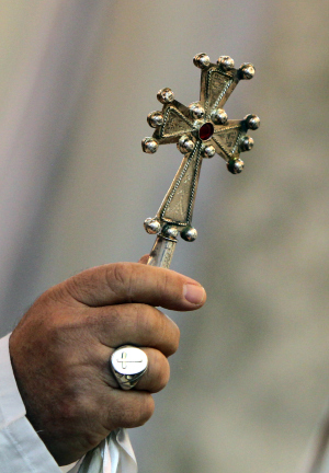 File photo of a Bishop holding a cross while leading mass. (Photo by AHMAD AL-RUBAYE/AFP/Getty Images)