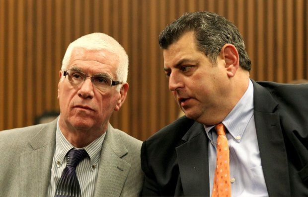 The Rev. James McGonegal, left, speaks with his attorney Henry Hilow before his arraignment in Cleveland Municipal Court Tuesday. McGonegal, a priest at St. Ignatius of Antioch Church, was arrested at Edgewater Park on charges for soliciting sex.