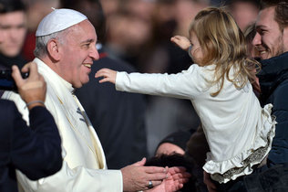 El papa Francisco se dispone a abrazar a una ninita el miercoles en la Plaza de San Pedro. El pontifice ha creado un panel especial sobre el escandalo de abuso sexual. FILIPPO MONTEFORTE / AFP/GETTY IMAGES