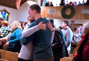 Mary Beth Just and her son, Justin Machia, wishing each other peace during a Christmas morning Mass at the Church of the Presentation in Upper Saddle River.