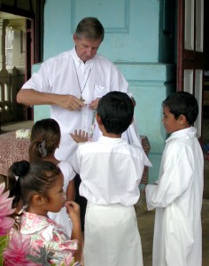 I found the Rev. Frank Klep handing out candy to young Samoan children after Mass. (File photo)