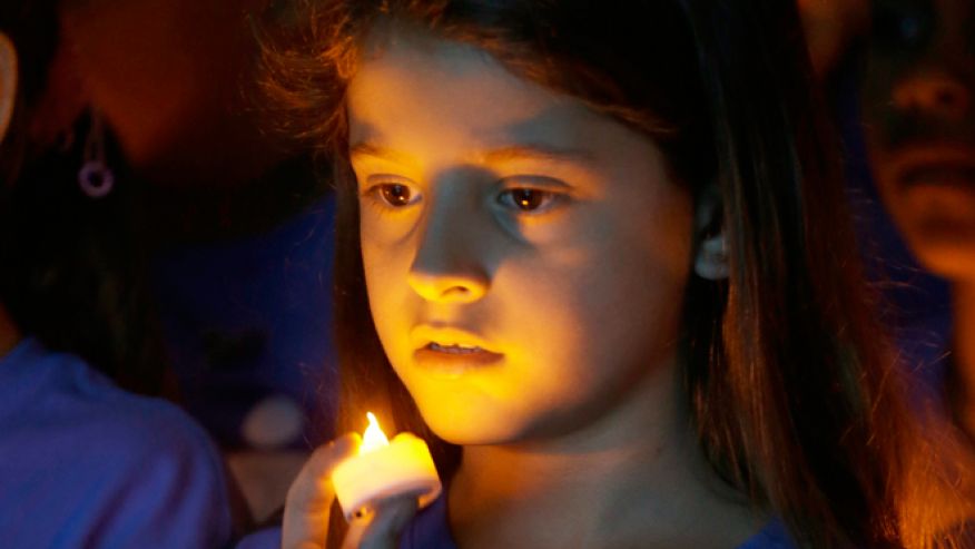 FILE -- April 23, 2014: Melanie Mamondes, 8, participates in a candlelight vigil commemorating National Child Abuse Prevention Month at Jose Marti Park in Miami. Amigos For Kids, a nonprofit organization dedicated to preventing child abuse and neglect, held the event attended by about 200 kids and their families.AP PHOTO/WILFREDO LEE