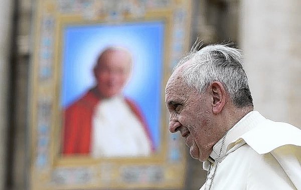 Pope Francis passes next to a tapestry of the late Pope John Paul II, as he leaves at the end of his weekly general audience at St. Peter's Square (Alessandro Bianchi Reuters, / April 30, 2014)