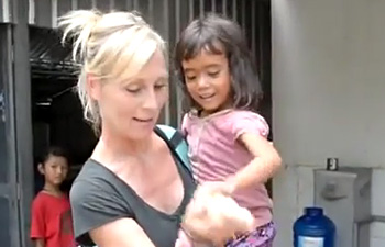 Stephanie Henry shows her bracelet to a girl at the Sao Sary Foundation in Cambodia.