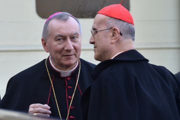 Vatican Secretary of State Pietro Parolin (L) speaks with former Vatican Secretary of State Tarcisio Bertone before the arrival of Pope Francis for a visit at the 'Bambino Gesu' Children's Hospital on December 21, 2013 in Rome. (Alberto Pizzoli/AFP/Getty Images)