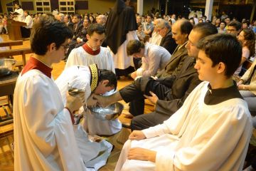 Priest Carlos Urrutigoity washes and kisses the foot of a churchgoer on Maundy Thursday in Paraguay's Ciudad del Este. (Vanguardia/Courtesy)