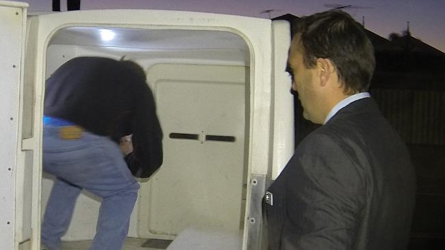 Druery is escorted into a police van this morning.