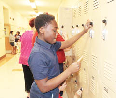 Duane Meighan, an eighth-grader at St. Thomas More School in Elgin, tries out his locker combination, Aug. 19. He and other students in diocesan schools are returning to classes this week, accompanied by bags full of new tools, motivation, and at least one tearful parent. (Observer photo by Margarita Mendoza)