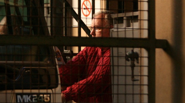 John Denham is escorted from court at an appearance in 2008. Photo: Kate Geraghty