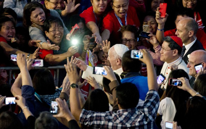 Pope Francis, center, followed by Cardinal Luis Antonio Tagle, waved as he arrived at the Mall of Asia arena, in Manila, Philippines on Jan. 16. (AP Photo/Alessandra Tarantino, File)