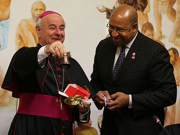 Archbishop Vincenzo Paglia, left, the President of the Holy See's Pontifical Council for the Family, rings a souvenir Liberty Bell, a gift from Mayor Michael Nutter, right, during their meeting at Pontifical Council for the Family in Rome, Italy on March 25, 2014. ( DAVID MAIALETTI / Staff Photographer )