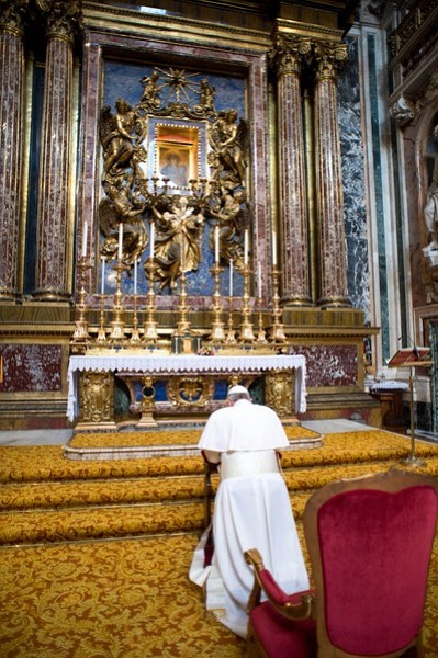 In this photo provided by the Vatican newspaper L’Osservatore Romano, Pope Francis kneels in prayer in front of the icon of the Virgin Mary inside St. Mary Major Basilica, in Rome, Thursday, March 14, 2014. Credit: AP