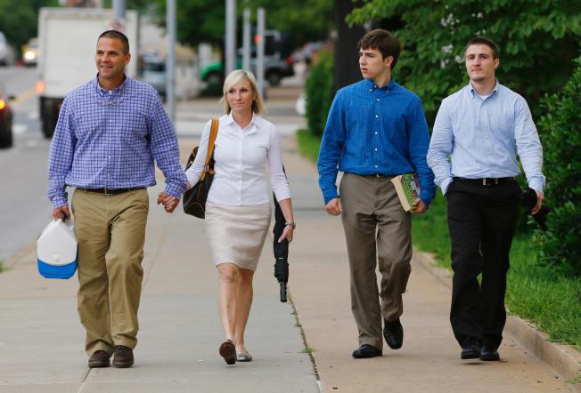 Kyle Durham, left, and Melissa Durham, second from left, hold hands as they leave the Federal Courthouse in Oklahoma City, following another day of testimony in the federal trial of their son, Matthew Lane Durham, Monday, June 15, 2015. At right are their other two sons, Josh Durham, right, and Zac Durham, second from right. Matthew Lane Durham is accused of 17 counts of sexual misconduct with children in Nairobi, Kenya. (AP Photo/Sue Ogrocki)