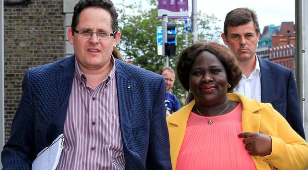 Dolores Atwood, a key witness, accompanied by her husband, Chris Atwood, leaving the High Court. RTE's Kevin Backhurst is in the background. Photo: Courtpix