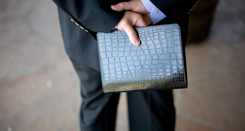 Image: Man holds Bible behind his back (Shutterstock.com)
