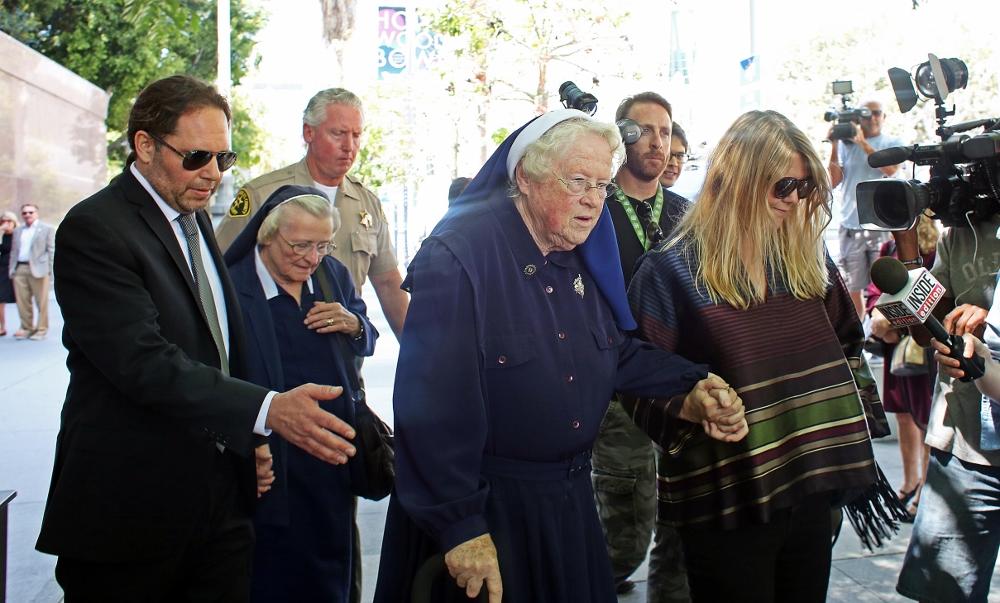 Srs. Catherine Rose Holzman, second left, and Rita Callanan, center, are escorted by businesswoman Dana Hollister, right, out of Los Angeles Superior Court on Thurs., July 30. The nuns are part of an order locked in a battle with Los Angeles' archbishop over the sale of their former convent, which pop singer Katy Perry wants to buy. A judge said July 30 that it appeared the nuns had improperly sold the property to Hollister, but warned the case will take months if not years to resolve. (AP Photo / Anthony McCartney)