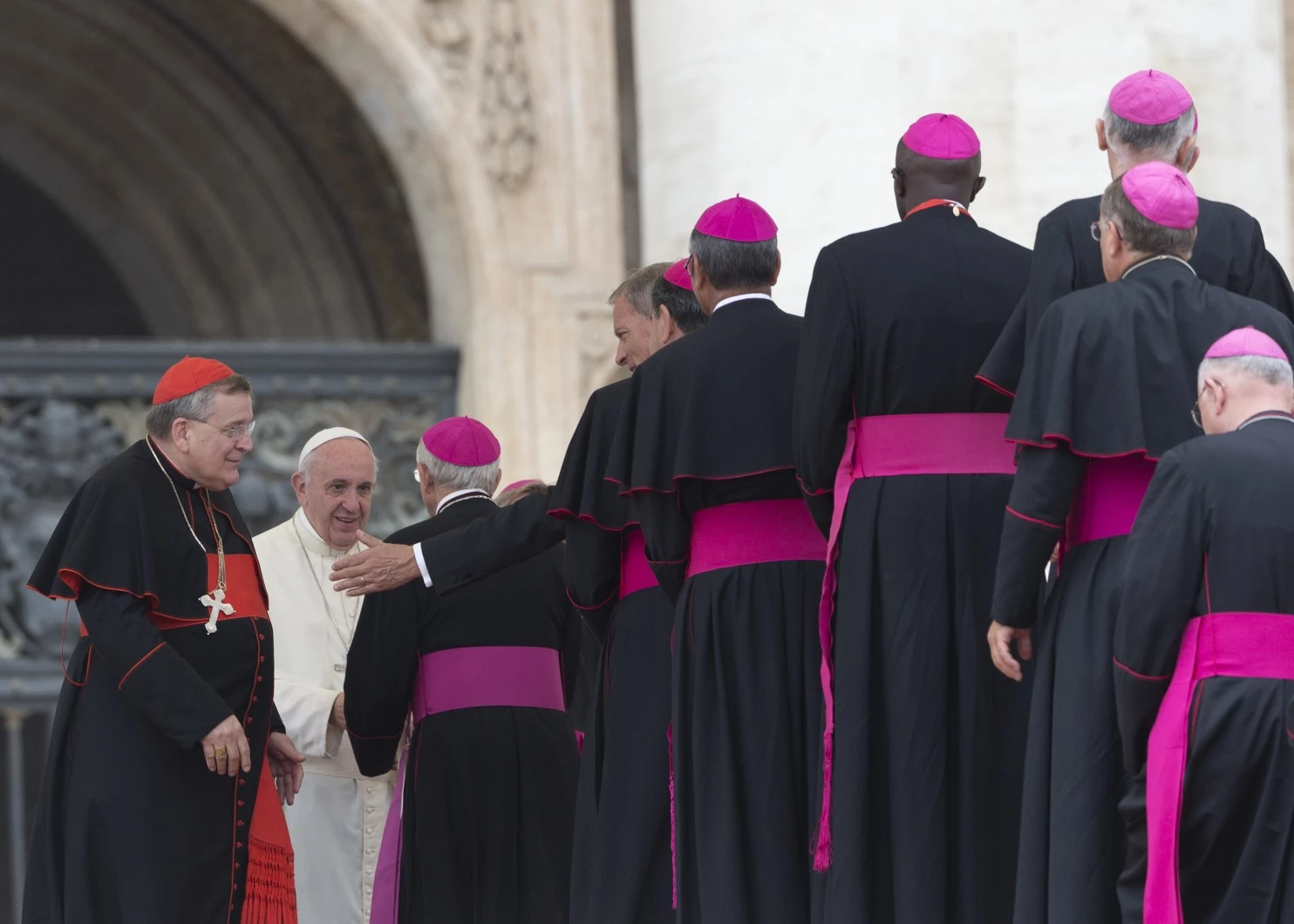 U.S. Cardinal Raymond Leo Burke, left, stands by Pope Francis saluting bishops, at the end of weekly general audience in St. Peter's Square at the Vatican, Sept. 2, 2015. (Alessandra Tarantino/AP)