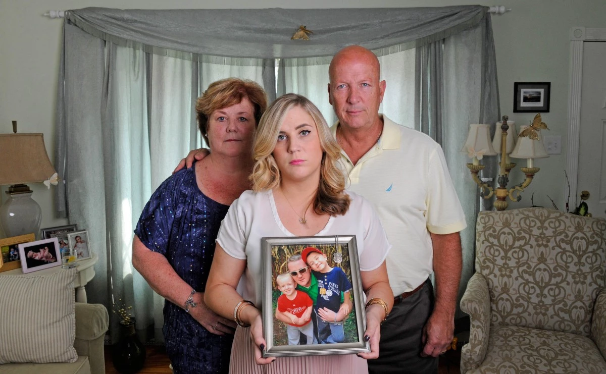 Debbie and Mike McIlmail, with daughter Kaitlyn. Kaitlyn holds a photo of Sean, with nephews Braden and Liam shortly before he died. (Katherine Frey/The Washington Post)