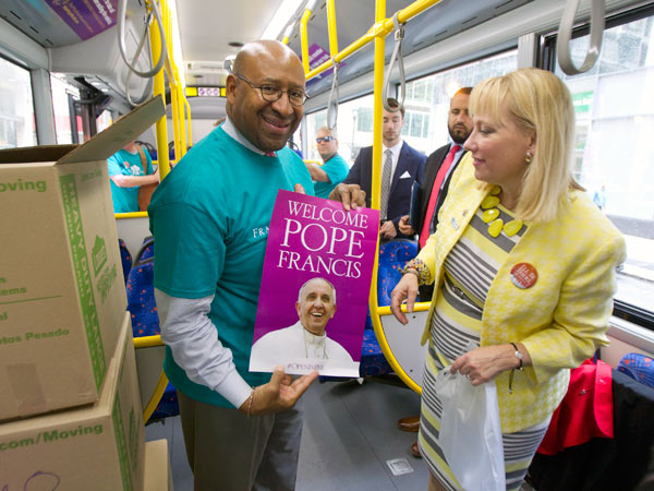 Mayor Michael Nutter, left, and Donna Crilley Farrell, executive director of the World Meeting of Families, show the poster from an "OpeninPHL" kit. (CHARLES FOX/Staff Photographer)