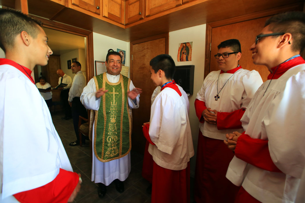 The Rev. Jesus Reynaga talking with altar boys before a Mass at Sacred Heart Church in Merced, last month.