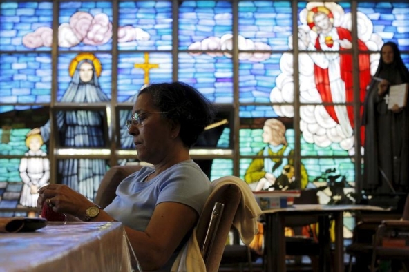 (Parishioner Maria Alves knits while keeping a vigil at St. Frances Xavier Cabrini Roman Catholic church in Scituate, Massachusetts July 22, 2015. REUTERS/Brian Snyder)