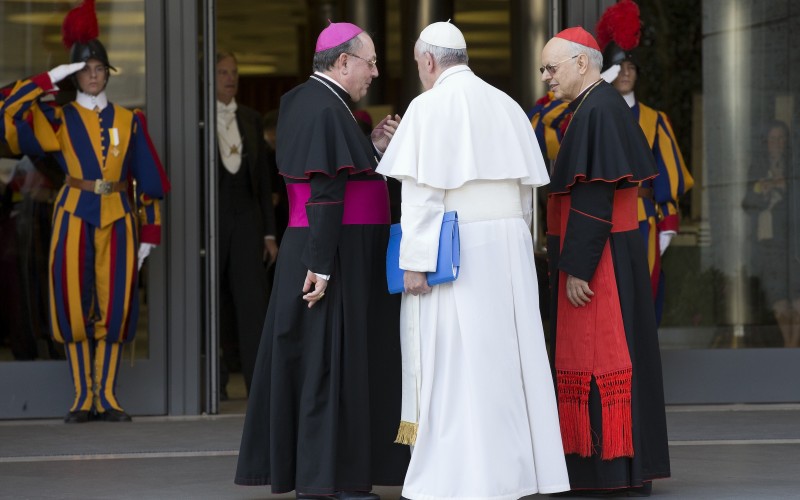 Pope Francis talks to Bishop Fabio Fabene and Cardinal Lorenzo Baldisseri outside the Vatican synod hall (AP)