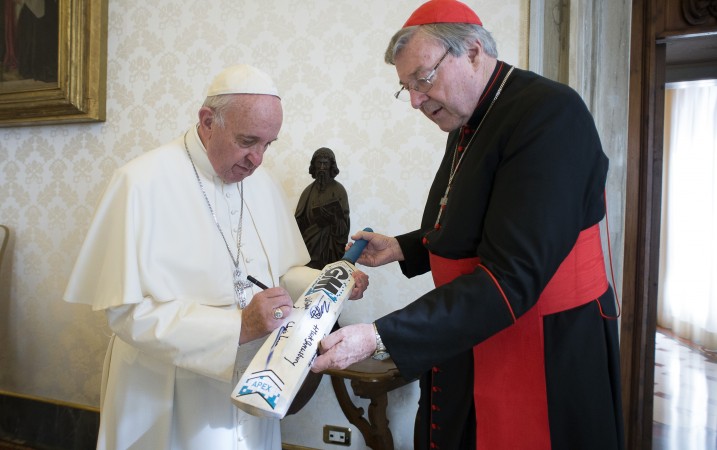 Pope Francis signed a cricket bat for Cardinal George Pell at the Vatican on Oct. 29 after the St. Peter's Cricket Club beat the Church of England's XI by 43 runs in a 20-over match. Pell says claims of lavish outlays by his department in two new books are "false and misleading."(L'Osservatore Romano/Pool Photo via AP)