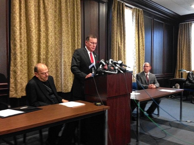 Syracuse Roman Catholic Diocese Bishop Robert Cunningham, on left, listens as Onondaga County District Attorney William Fitzpatrick talks at a news conference Oct. 28, 2015 in Binghamton, N.Y. On the right is Oswego County District Attorney Greg Oakes. The diocese reached an agreement with seven district attorneys in Central New York to immediately notify them if they suspect a priest or diocese official of sexually abusing a child.