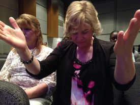 Amy Drummond of Marietta bows in prayer for victims of child sexual abuse. Drummond, who was sexually abused, was among those ... Read More