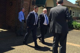 PHOTO: Father Patrick Kervin, also known as Father Pat (centre with blue tie) leaves Albion Park Local Court, Friday October 16, 2015 (ABC News Nick McLaren)