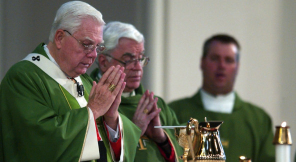 Cardinal Bernard Law, left, celebrates mass at the Cathedral of the Holy Cross in Boston Sunday, July 21, 2002. Law resigned in disgrace as archbishop of Boston over his role in the clergy sex abuse crisis. (John Bohn/ AP)