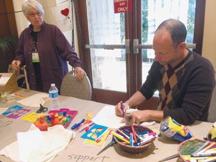 Beyond Silence attendees work at an art table.