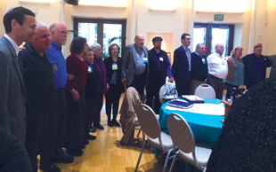 Conference participants gather in a closing circle after a day of workshops.