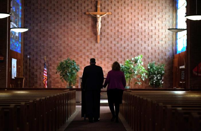 Jon and Maryellen Rogers, spokespeople, Friends of St. Frances X. Cabrini return the lectern to the church's alter after a press conference in October.